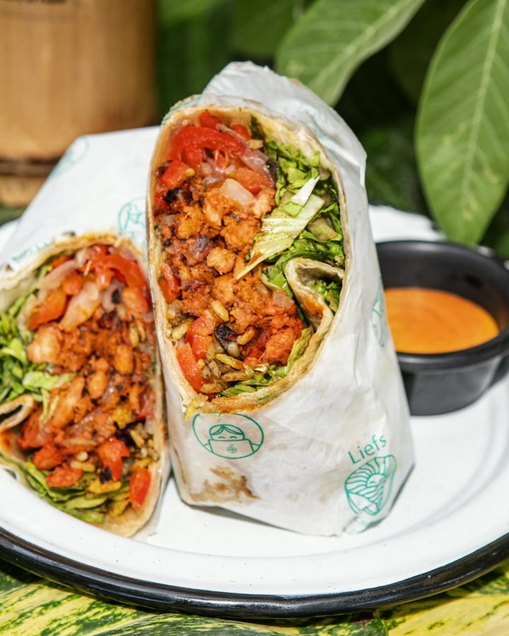 Vegan burrito cut open to show rice, vegetables and lettuce at Liefs Tulum