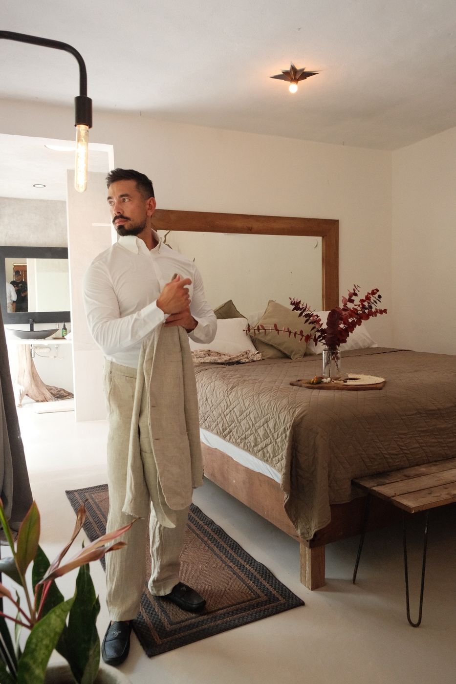 Groom getting ready in the bedroom at Rancho Verde Tulum